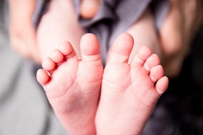 person holding babys feet